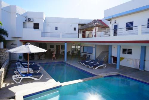 威廉斯塔德Boca Simon Vacation Curacao的一座带椅子和遮阳伞的大楼前的游泳池