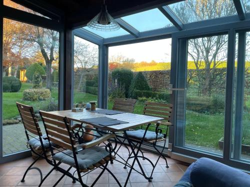 布兰肯海姆Haus-Hoeppches的带窗户的客房内的温室配有桌椅