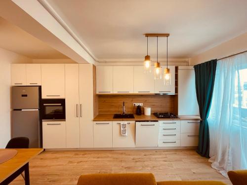 弗洛雷什蒂A&Y APARTAMENT的厨房配有白色橱柜和桌子