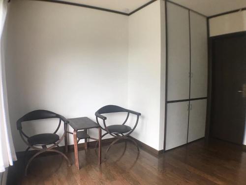 富士宫市ゆののうち的房间里的两张椅子和一张桌子