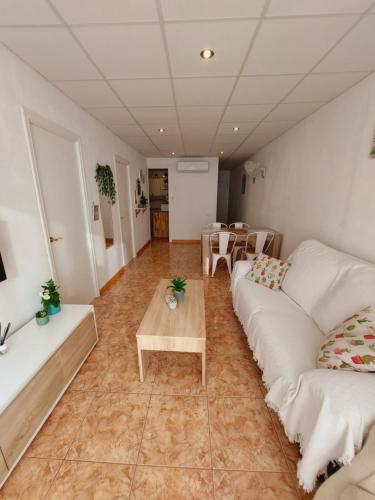 霍斯皮塔勒·德尔英福Apartamento Sant Roc的客厅配有2张白色沙发和1张桌子