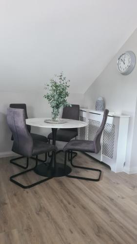 Cluain EoisOld Farmhouse Annex的餐桌、两把椅子和一张白色桌子