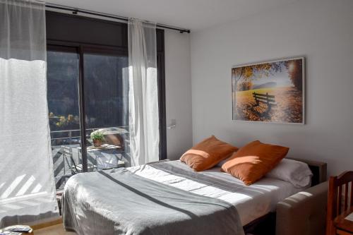 埃尔塔特Apartament Mufló Apartamento encantador con vistas espectaculares a la X de Grandvalira的一间卧室设有一张床和一个大窗户