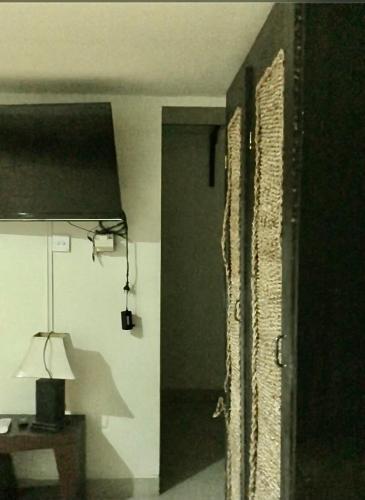 UjungSacca Studio Home in Benoa的一间设有门、一盏灯和一张桌子的房间