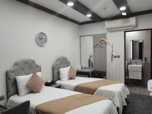沙迦Daraysh Hotel的酒店客房设有两张床和盥洗盆