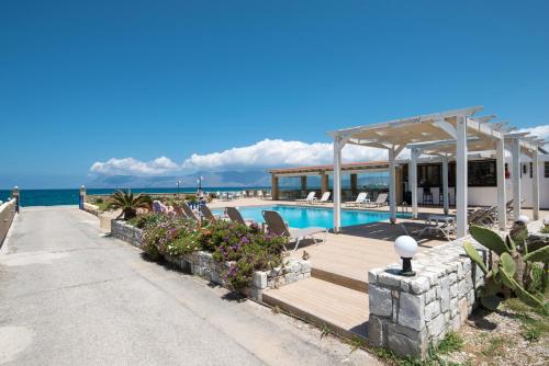 基萨莫斯Captain's Beach Apartments的一个带游泳池和海洋的度假胜地