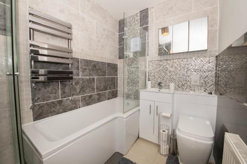 布里德灵顿EmmaDale Central Bridlington sleeps 7-8的浴室配有卫生间、浴缸和水槽。
