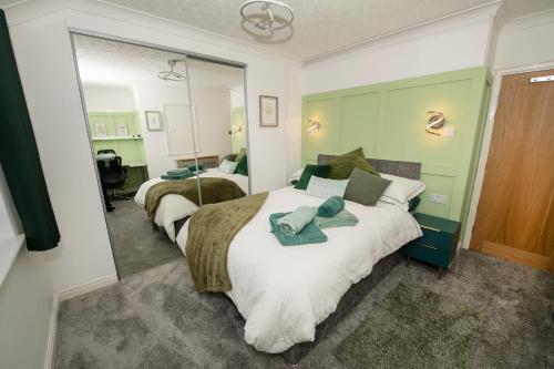 布里德灵顿EmmaDale Central Bridlington sleeps 7-8的一间卧室设有两张床和大镜子