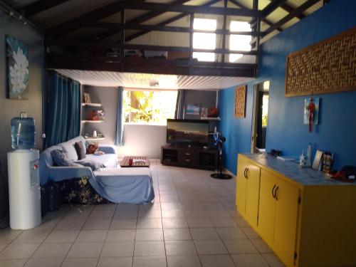 乌图罗阿VILLA DE LA BAIE RAIATEA的客厅设有蓝色的墙壁和黄色的橱柜。