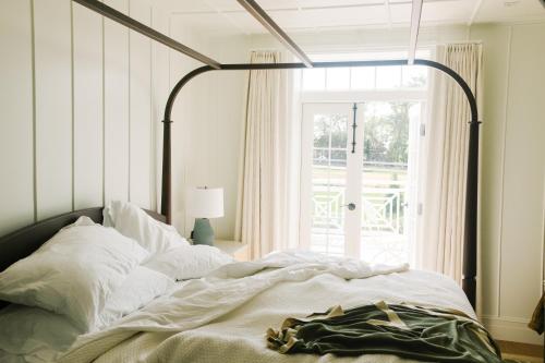 汉普顿贝斯Canoe Place Inn & Cottages的一间卧室设有一张大床和大窗户