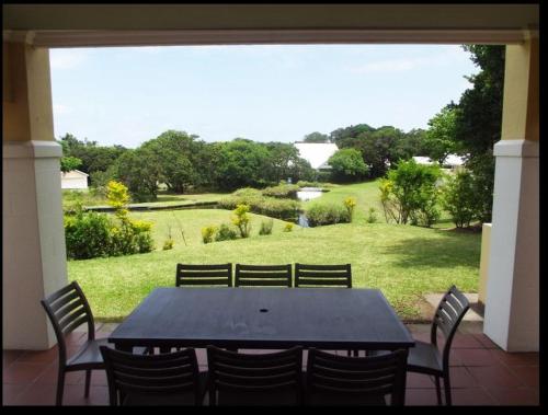 爱德华港Caribbean Estates Villa Caylee - Ultra-Luxurious - Rimas Interiors Designs - Private Beachfront Escape - Premium serviced for 8 Guests的一张带椅子的黑桌,享有田野的景色