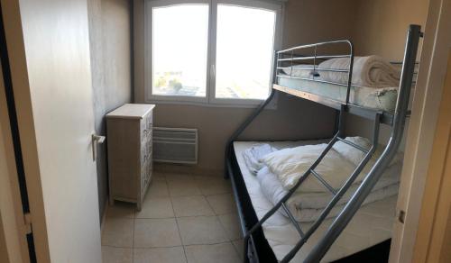 圣让-德蒙Cap Eden的客房设有两张双层床和一扇窗户。