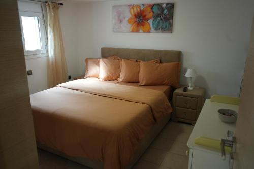 阿特米达Cozy apartment near sea and airport的一间卧室配有带橙色床单的床和窗户。