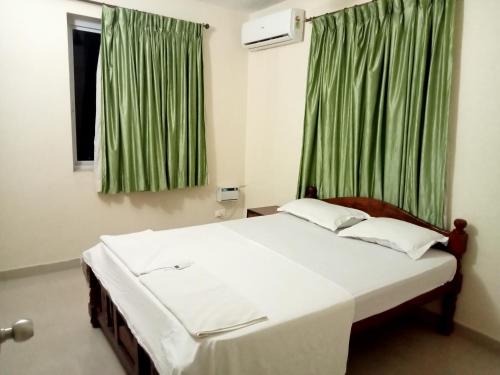 瓦尔恰Asian Paradise comfort的一间卧室配有一张带绿色窗帘的大床