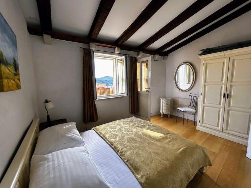 杜布罗夫尼克Beautifully Restored 400-year Old House with Stunning Sea Views from the Terrace的一间卧室设有一张床和一个大窗户