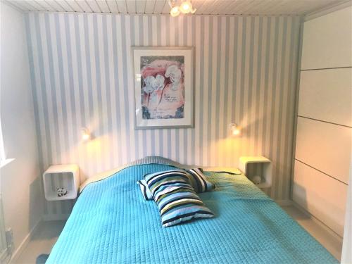 蒙克博Dejlig feriebolig med havudsigt i naturskønt område的一间卧室配有一张蓝色的床和条纹墙