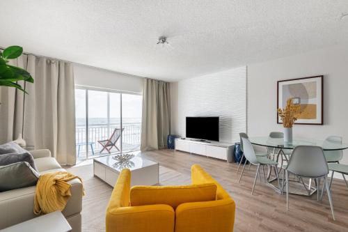 卫星海滩Oceanfront Beach House, Satellite Beach的客厅配有黄色的沙发和桌子