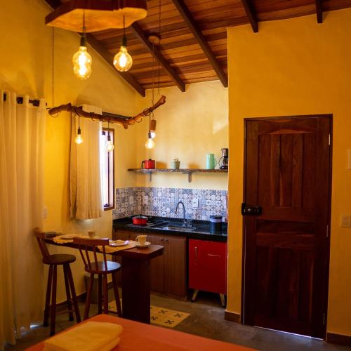戈亚斯州上帕莱索Espaço Canela-de-Ema的厨房设有黄色的墙壁、桌子和柜台