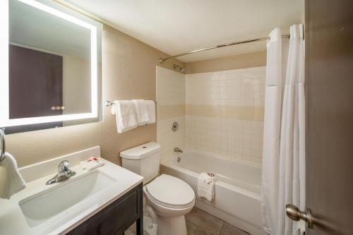 拉雷多Baymont by Wyndham Laredo的浴室配有卫生间、盥洗盆和浴缸。