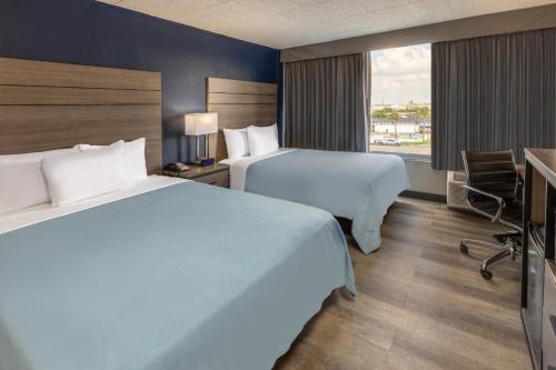 拉雷多Baymont by Wyndham Laredo的酒店客房设有两张床和窗户。