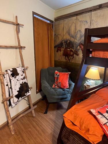 坎顿Acorn Hideaways Canton Old Western Ranch Hands' Suite的一间带床、椅子和梯子的房间