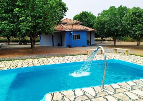 诺布里斯Pousada Canto das Araras - Vila Bom Jardim Nobres MT的一座房子前面的游泳池,喷泉