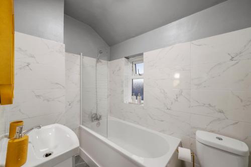 斯特鲁德Cosy home in Rochester, sleeps 6的白色的浴室设有白色浴缸和水槽。