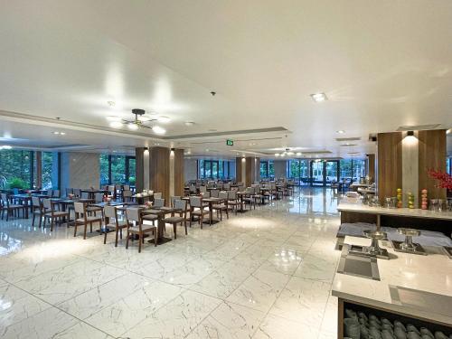 潘郎Long Thuan Hotel & Resort的用餐室设有桌椅和窗户。