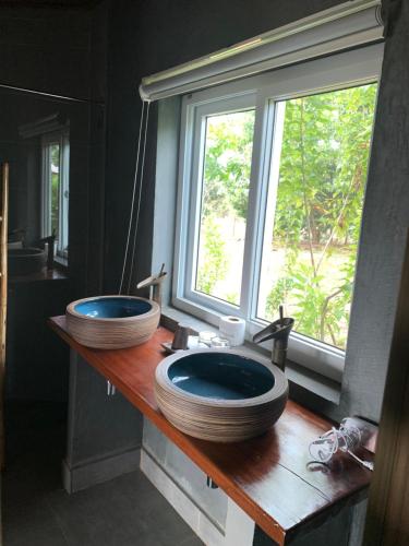 森莫诺隆Sumeru的一个带窗户的木柜台上带两个水槽的浴室