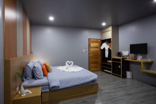 拉差汶里The Sun resort Ratchaburi的一间卧室配有一张床和一张书桌及电视