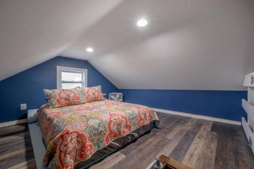坦帕Blue Bay Suite! Near Downtown and Foodie Hot Spots的一间卧室设有一张床和蓝色的墙壁
