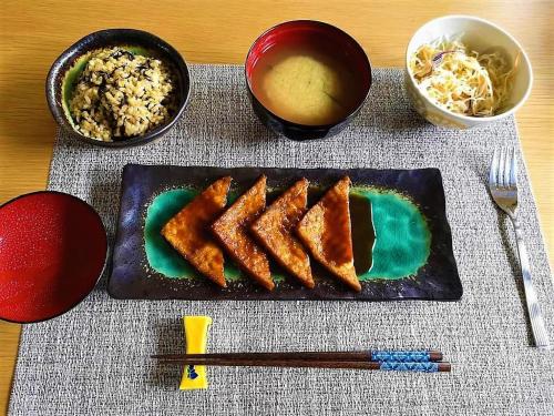 京都Vegan Minshuku Sanbiki Neko的桌上的饭盘,有筷子和米饭