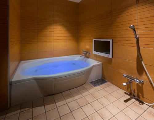 丰田市HOTEL K's MINE的带电视的浴室设有大浴缸