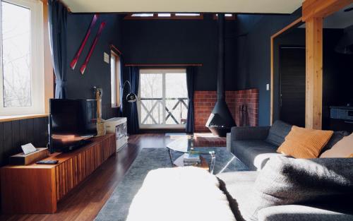 二世古Goodfellas Onsen House的带沙发和电视的客厅