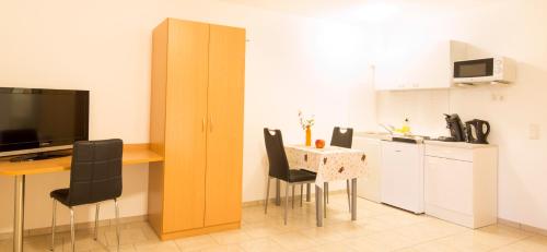 弗莱堡Haus Emona - Ihre Pension in Freiburg的厨房配有桌椅和桌子,厨房配有柜台。