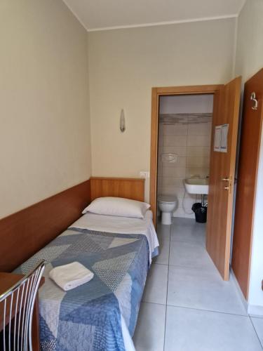 米兰博诺拉酒店的一间卧室配有一张床,浴室设有水槽