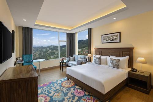 西姆拉Fortune Park Kufri, Shimla - Member ITC's Hotel Group的酒店客房设有一张床和一个大窗户