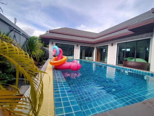 甲米镇Siri Nathai Pool Villa สิรินาไทย พูลวิลล่า的一座房子旁的游泳池,设有充气泳池面