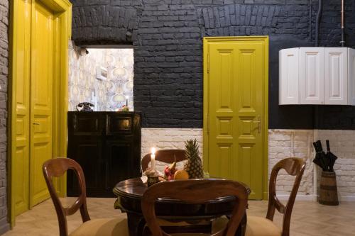 布达佩斯Metropolis Budapest Boutique Hotel的用餐室设有黄色门和桌椅