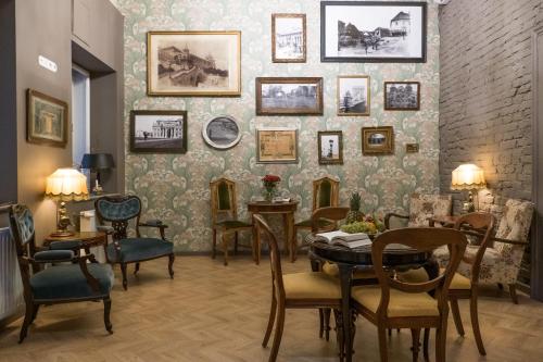 布达佩斯Metropolis Budapest Boutique Hotel的配有桌椅和画墙的房间