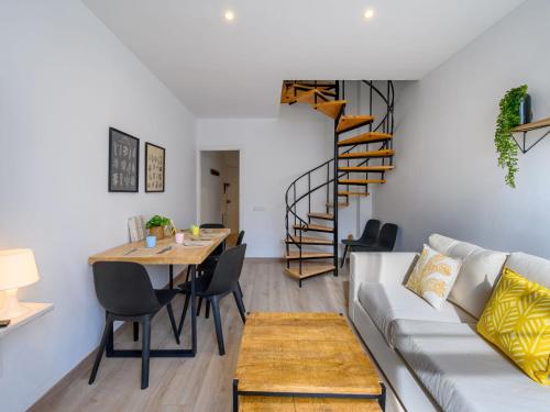 拉莫利纳Apartment Ginesta by Interhome的带沙发和桌子的客厅以及螺旋楼梯。