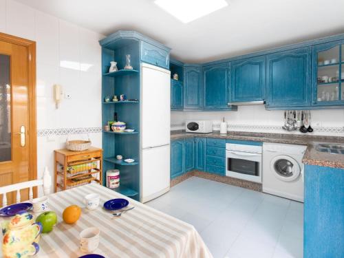 托雷德本纳贾尔邦Holiday Home Villa Corales by Interhome的厨房配有蓝色橱柜和白色冰箱