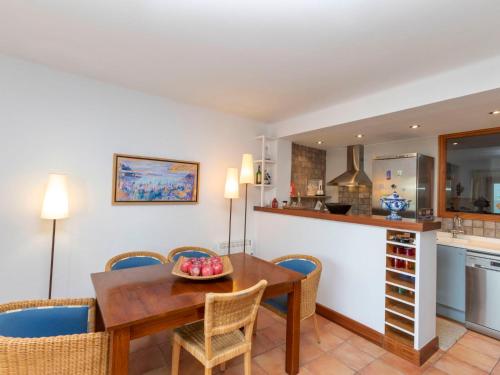 巴古尔Apartment Sa Riera Beach by Interhome的厨房以及带木桌和椅子的用餐室。