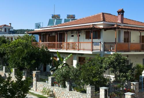 斯基亚索斯镇潘申马托拉公寓的带阳台的房屋,前面有树木