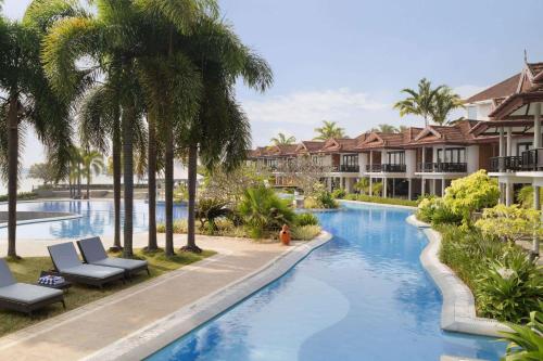 科钦Ramada Resort by Wyndham Kochi的棕榈树度假村的游泳池