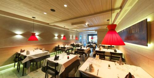 博西佩伊旅馆的一间设有白色桌子和红灯的餐厅