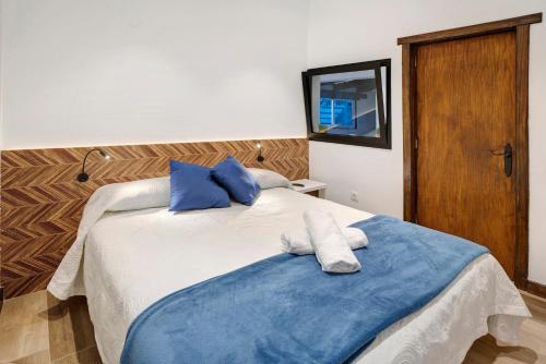 坎德拉里亚Casa Miranda的一间卧室配有两张带蓝白色毛巾的床