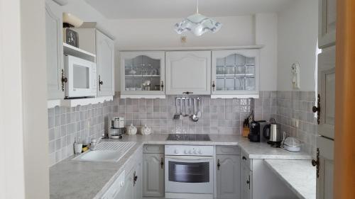 安嫩海姆Gemütliche Ferienwohnung的白色的厨房配有白色橱柜和水槽