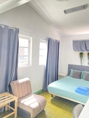 普拉亚Best Rooms - Quarto 1 Plateau的一间卧室配有蓝色的床和椅子