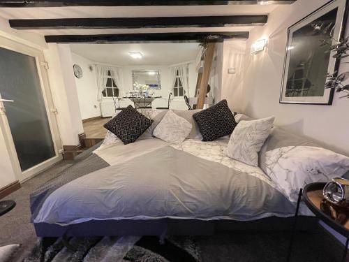 奇德尔Tollgate House - Luxury Cozy Cottage - HUGE Hot Tub - Alton Towers的一间卧室配有一张大床和枕头